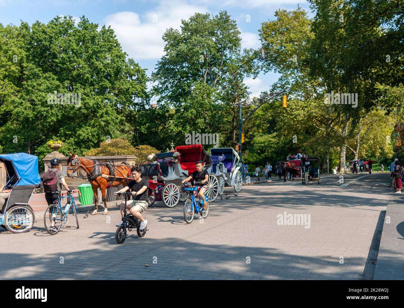 Carrozze trainate da cavalli, scooter, corridori e biciclette sulla trafficata 72nd Street Transverse a Central Park a New York sabato 17 settembre 2022. (© Richard B. Levine) Foto Stock