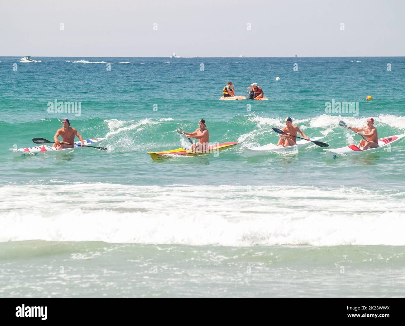 Tauranga Nuova Zelanda - Gennaio 25 2009; i paddlers sull'ultima onda alle corse del litorale è la concorrenza di surfsalvataggio Foto Stock