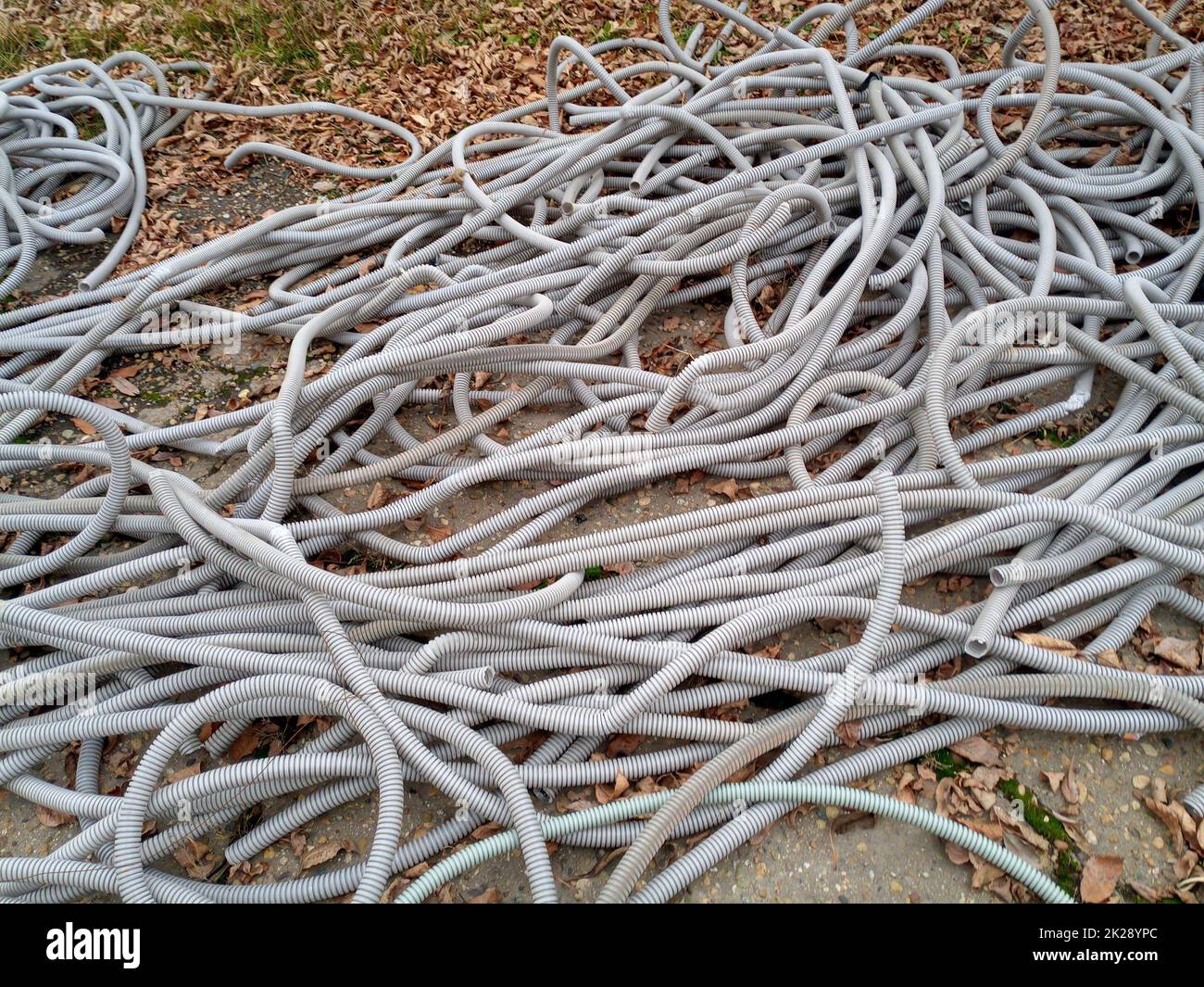 I tubi corrugati per il cablaggio elettrico si trovano a massa. Foto Stock