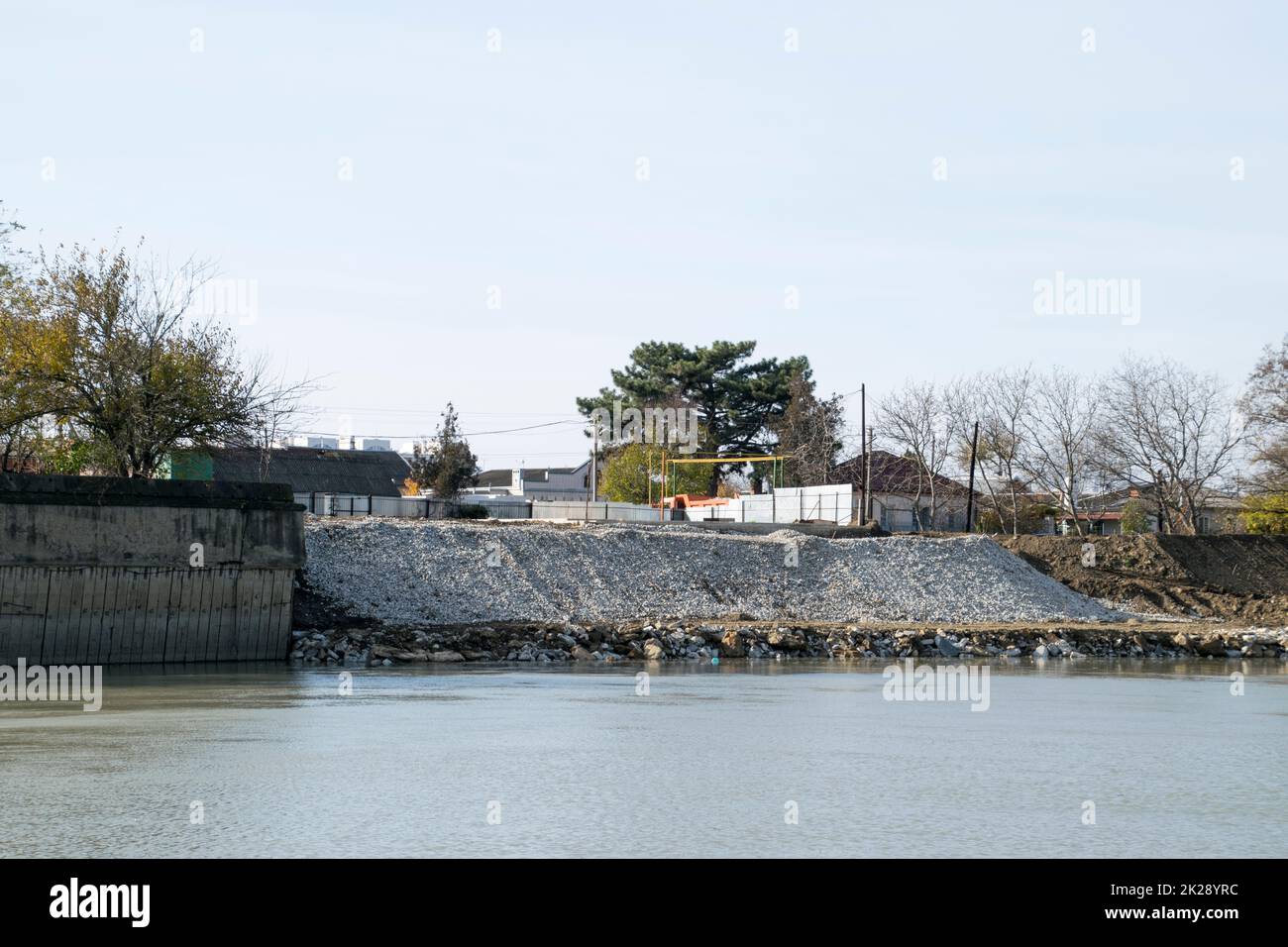 Rafforzamento dell'argine del fiume in città Foto Stock
