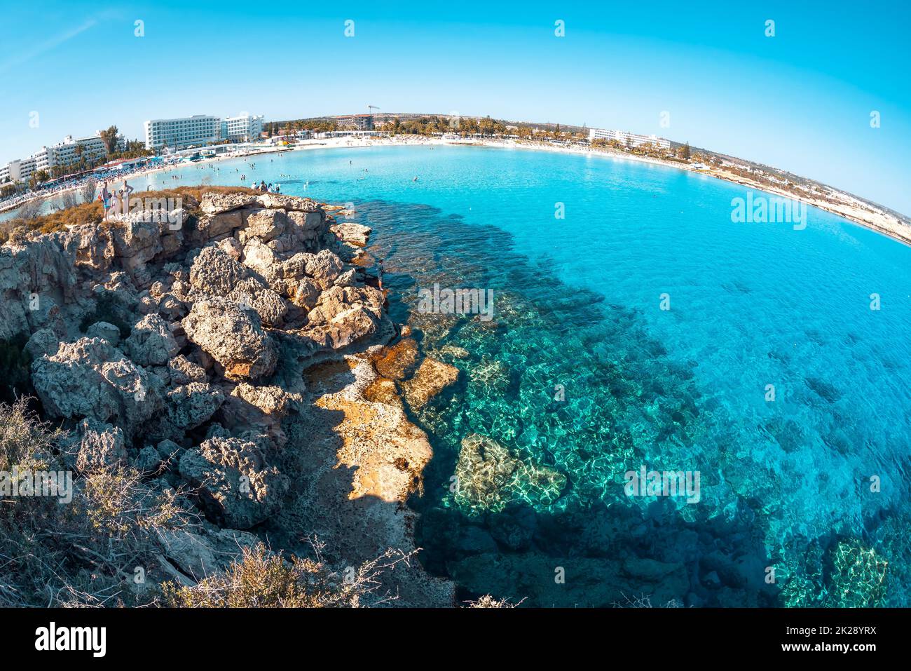 Litorale a Nissi Beach, vista da un isolotto roccioso. Ayia Napa, Distretto di Famagosta, Cipro Foto Stock
