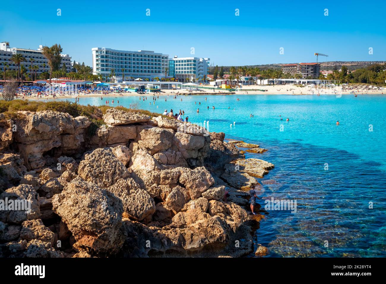 Litorale a Nissi Beach, vista da un isolotto roccioso. Ayia Napa, Distretto di Famagosta, Cipro Foto Stock