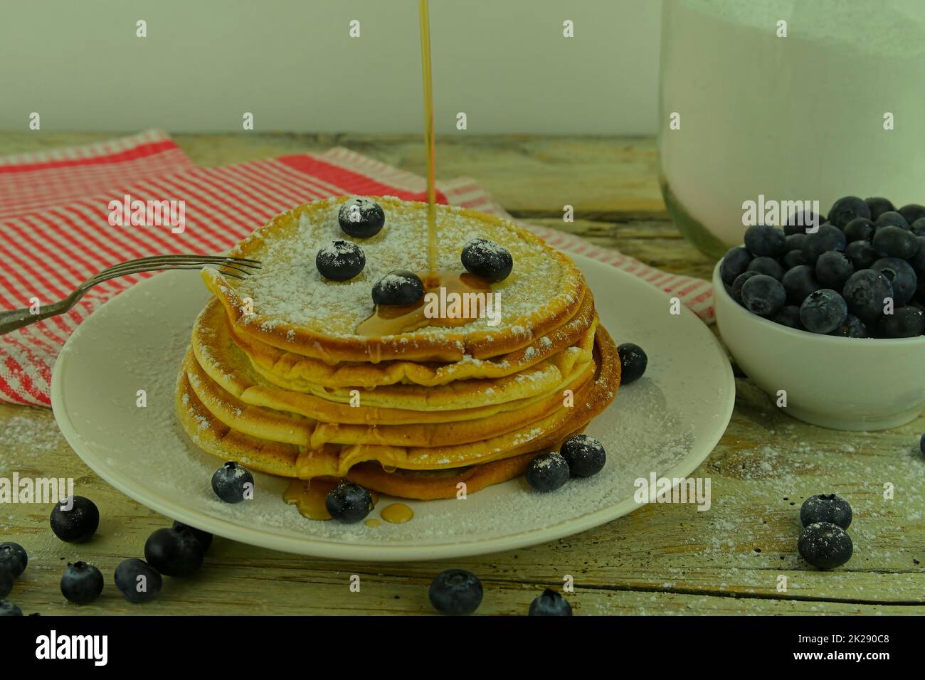 Deliziosi pancake con mirtilli freschi e sciroppo su un rustico tavolo di legno. Sciroppo d'acero e mirtilli su pila di frittelle. Rustico tavolo bianco. Primo piano Foto Stock