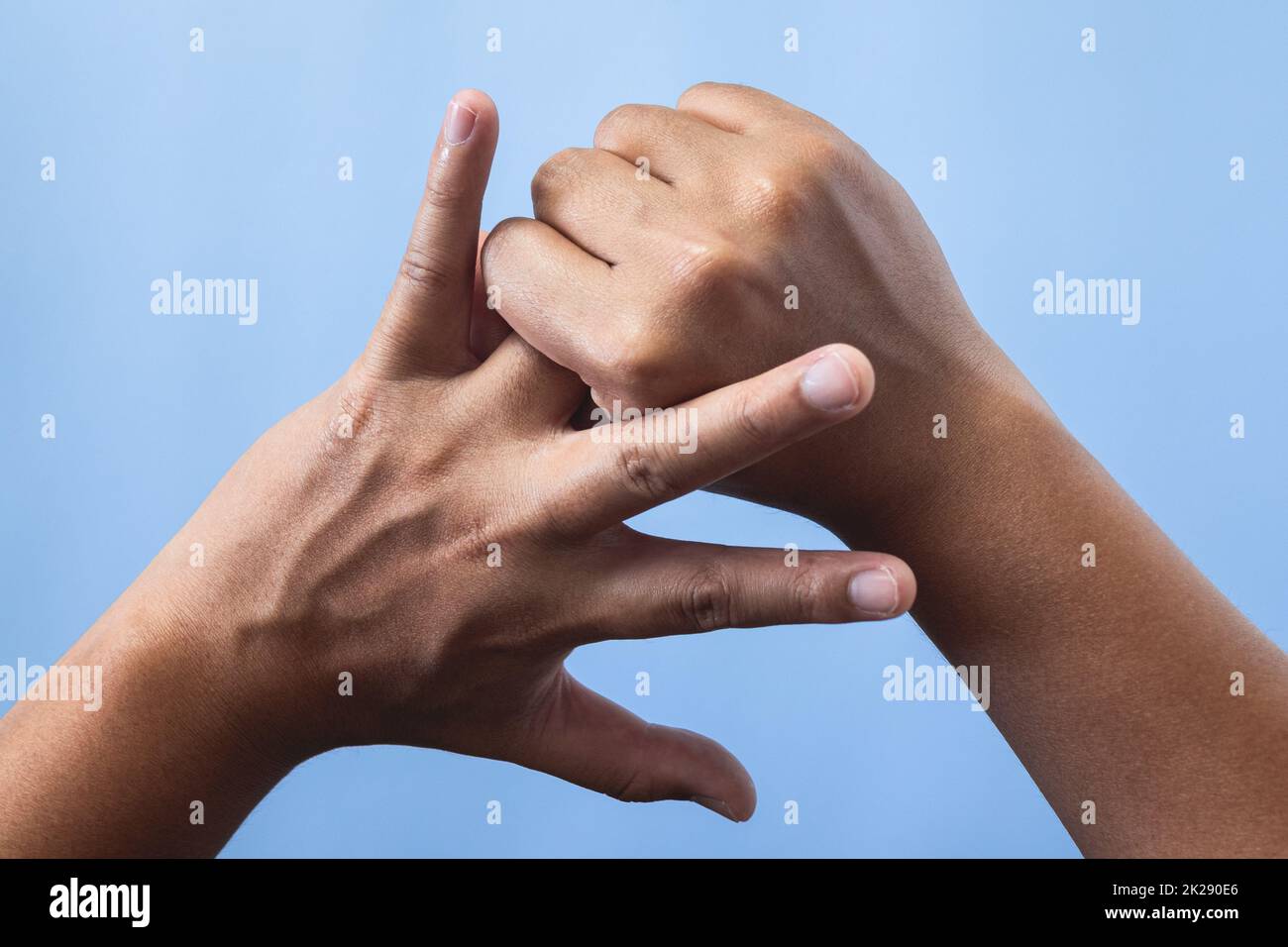 Concetto di sindrome da ufficio. La ghiera viene massaggiata e allungata dopo il lavoro. Primo piano isolato su sfondo blu. Vista posteriore. Foto Stock