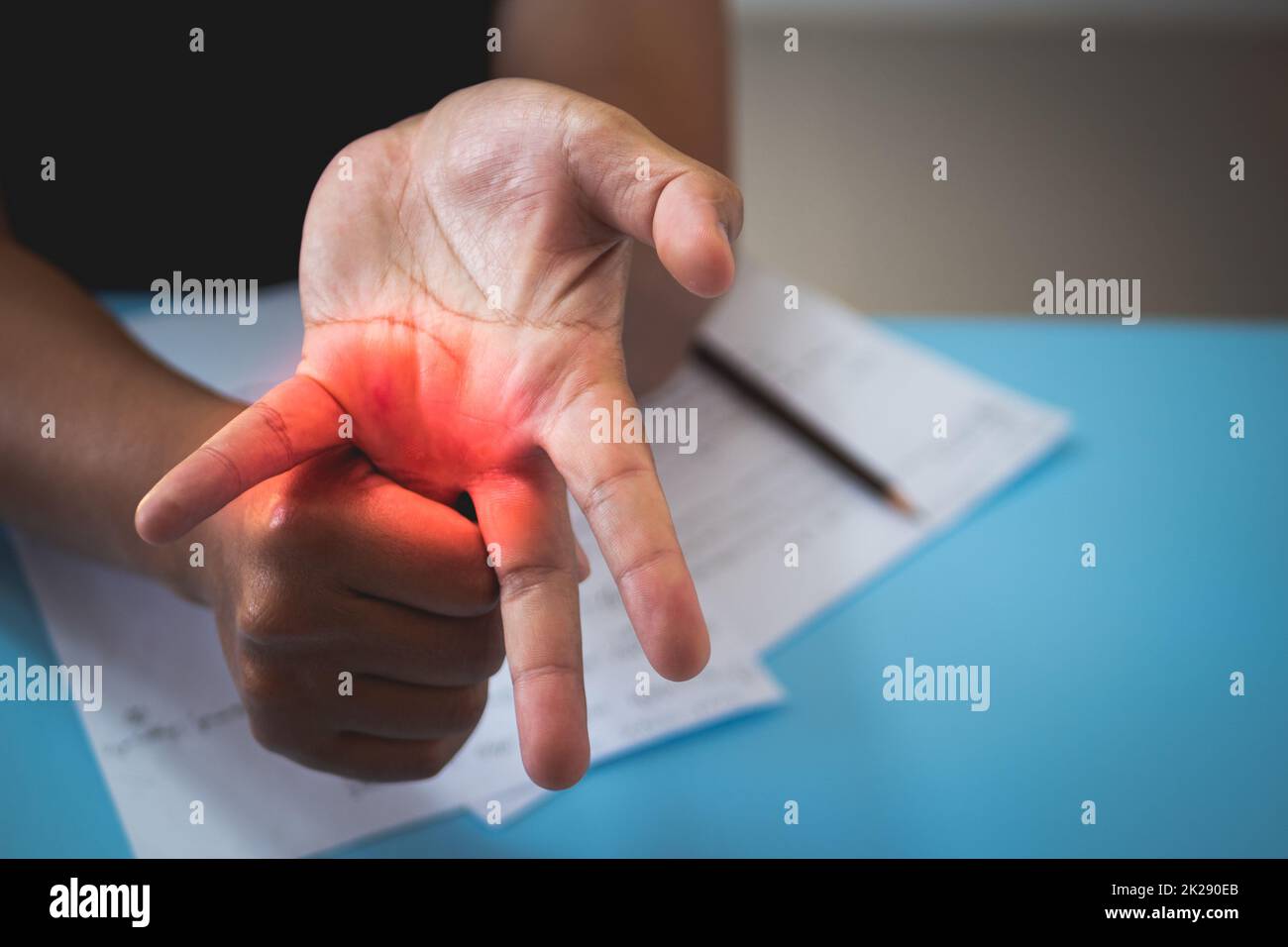 L'uomo allunga il dito dell'anello dopo che ha lavorato. Concetto di sindrome da ufficio. L'area del sintomo dolore è visualizzata in rosso. Primo piano. Foto Stock