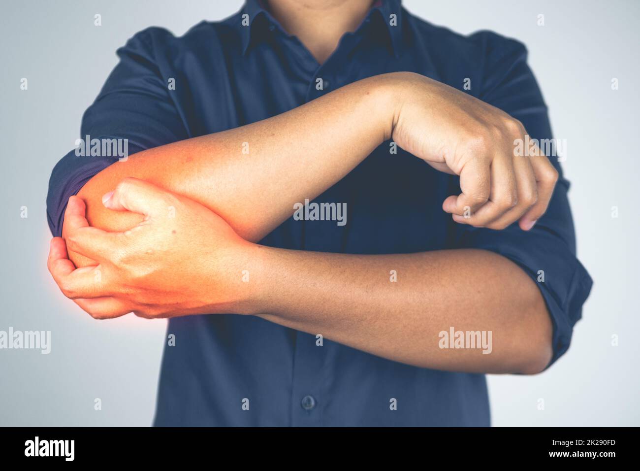 Danno al gomito da tennis e golf. L'uomo tiene il braccio. L'area del sintomo dolore è visualizzata in rosso. Conoscenze sanitarie. Primo piano medio. Foto Stock