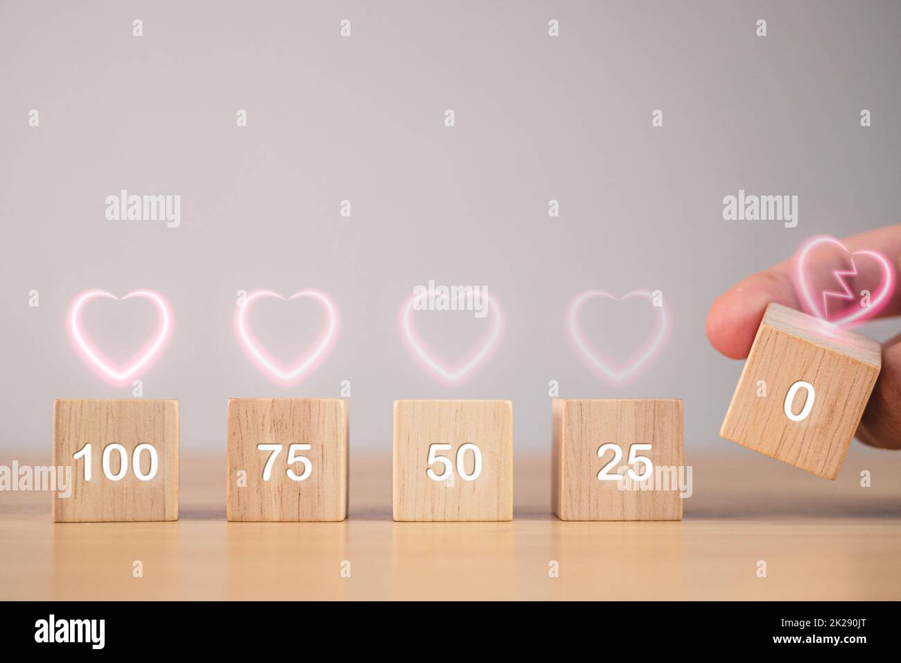 Il concetto di San Valentino. Livello di Amore da 100 a 0%. I blocchi di legno cubico hanno effetto visivo in forma di cuore rosa. C'è spazio per la copia del testo. Foto Stock
