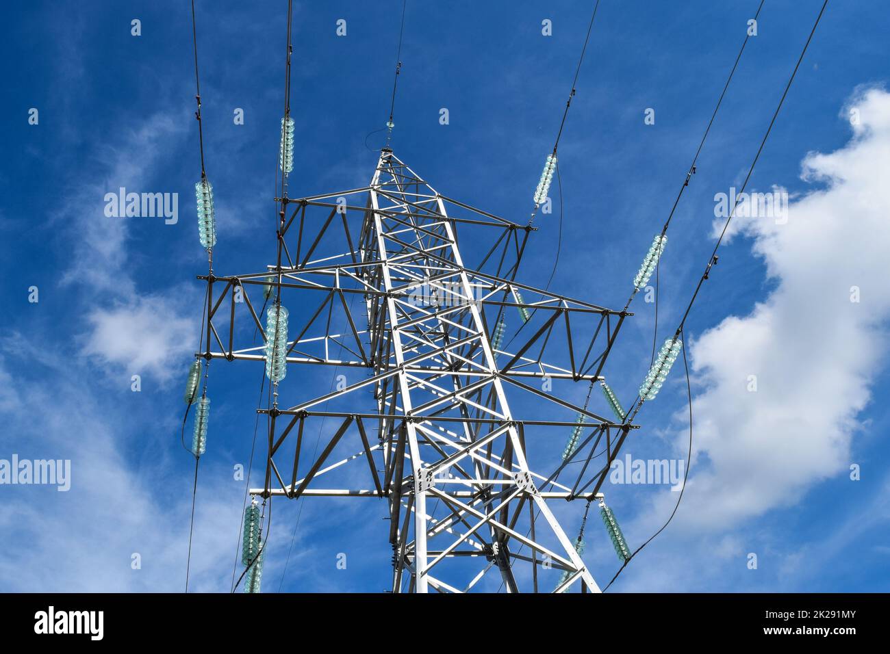 Supporta le linee elettriche ad alta tensione contro il cielo blu con nuvole. Industria elettrica Foto Stock