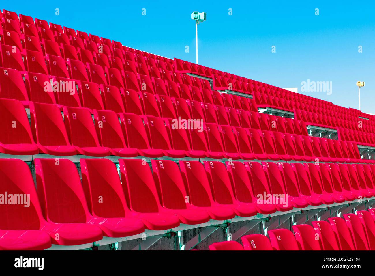 Fila di posti a sedere vuoti in plastica rossa sullo stadio sulla terrazza Foto Stock