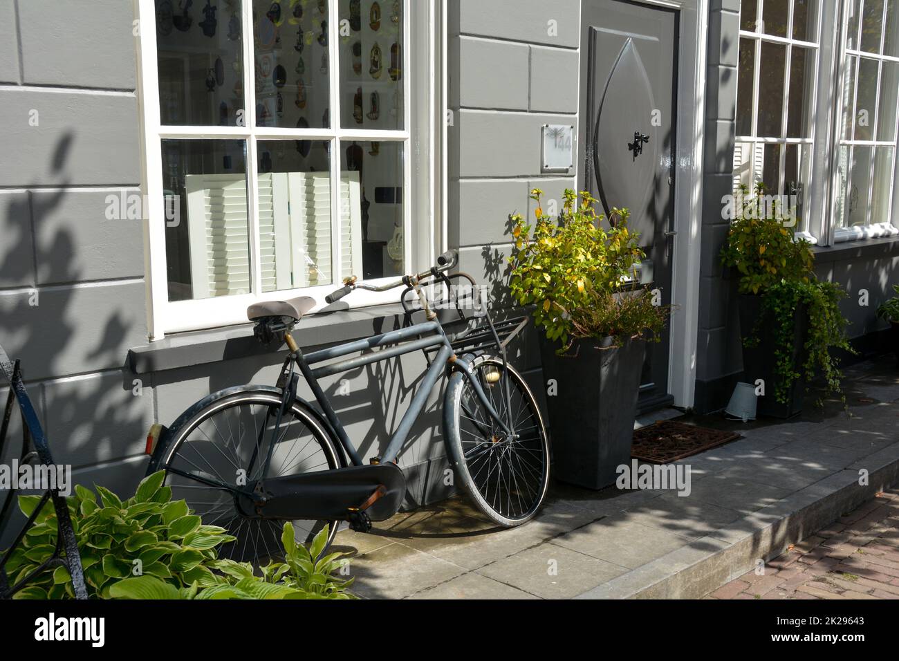 Tipica strada olandese - una bicicletta appoggiata alla facciata di una casa Foto Stock