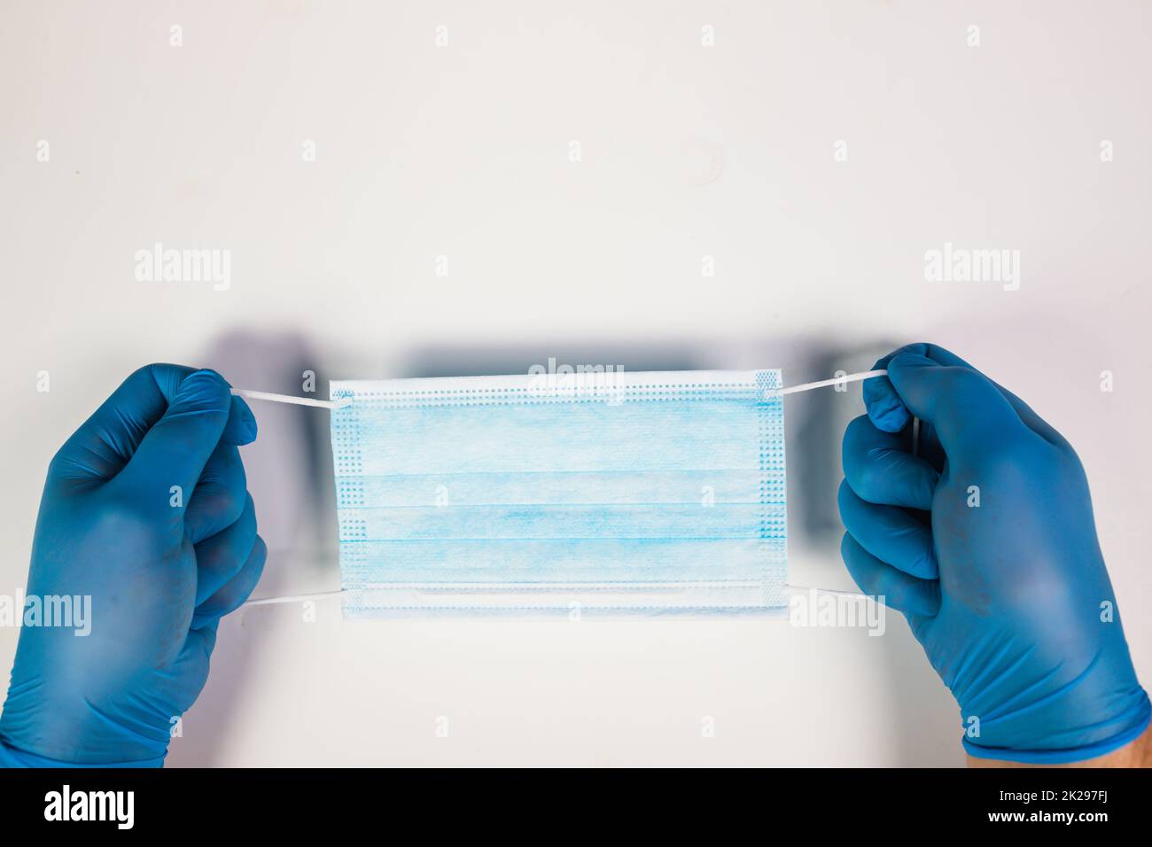 Primo piano della mano del medico che tiene la maschera chirurgica Foto Stock