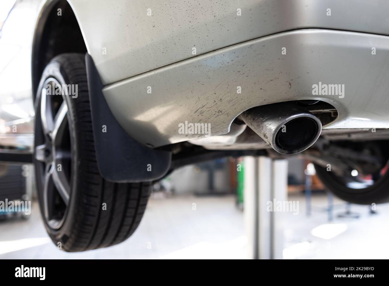 Auto in garage per manutenzione, cambio olio/pneumatico (immagine con toni bassi DOF) Foto Stock