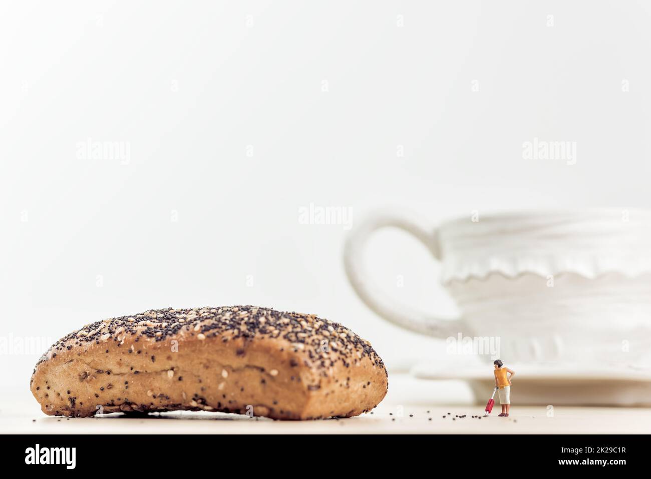 Donna casual in miniatura con aspirapolvere a tavolo da cucina Foto Stock