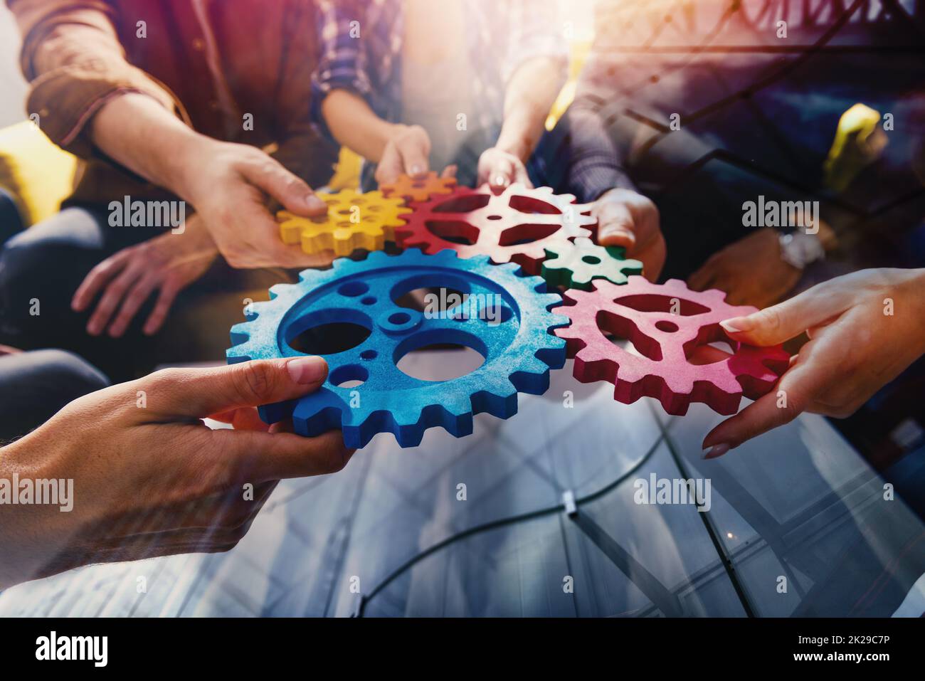 Il team aziendale collega componenti di ingranaggi come un lavoro di squadra e partner Foto Stock