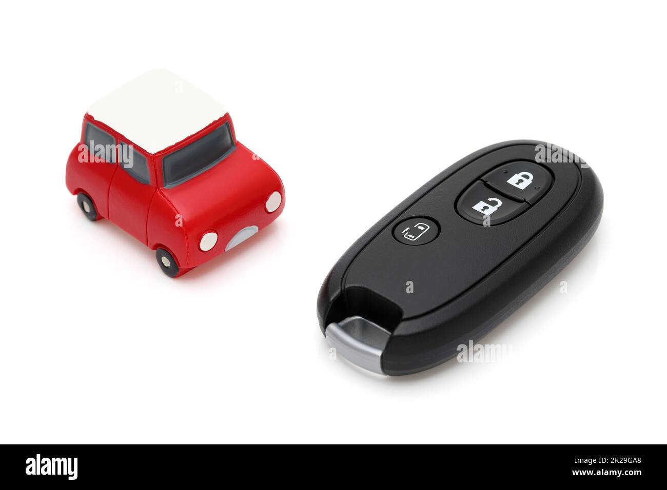 Telecomando con chiave nera per auto e piccola auto giocattolo su sfondo  bianco Foto stock - Alamy