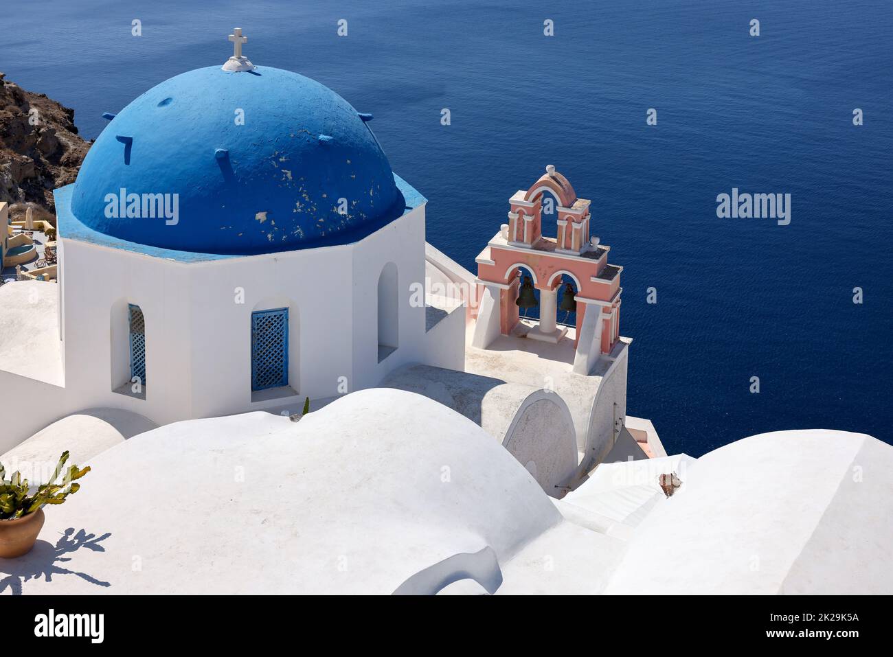 Vista dal punto di vista del villaggio di Oia con cupola blu della chiesa cristiana ortodossa greca. Santorini Foto Stock