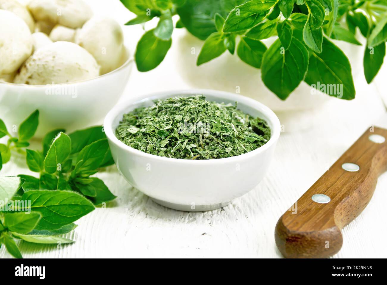 Origano essiccato in ciotola a bordo Foto Stock