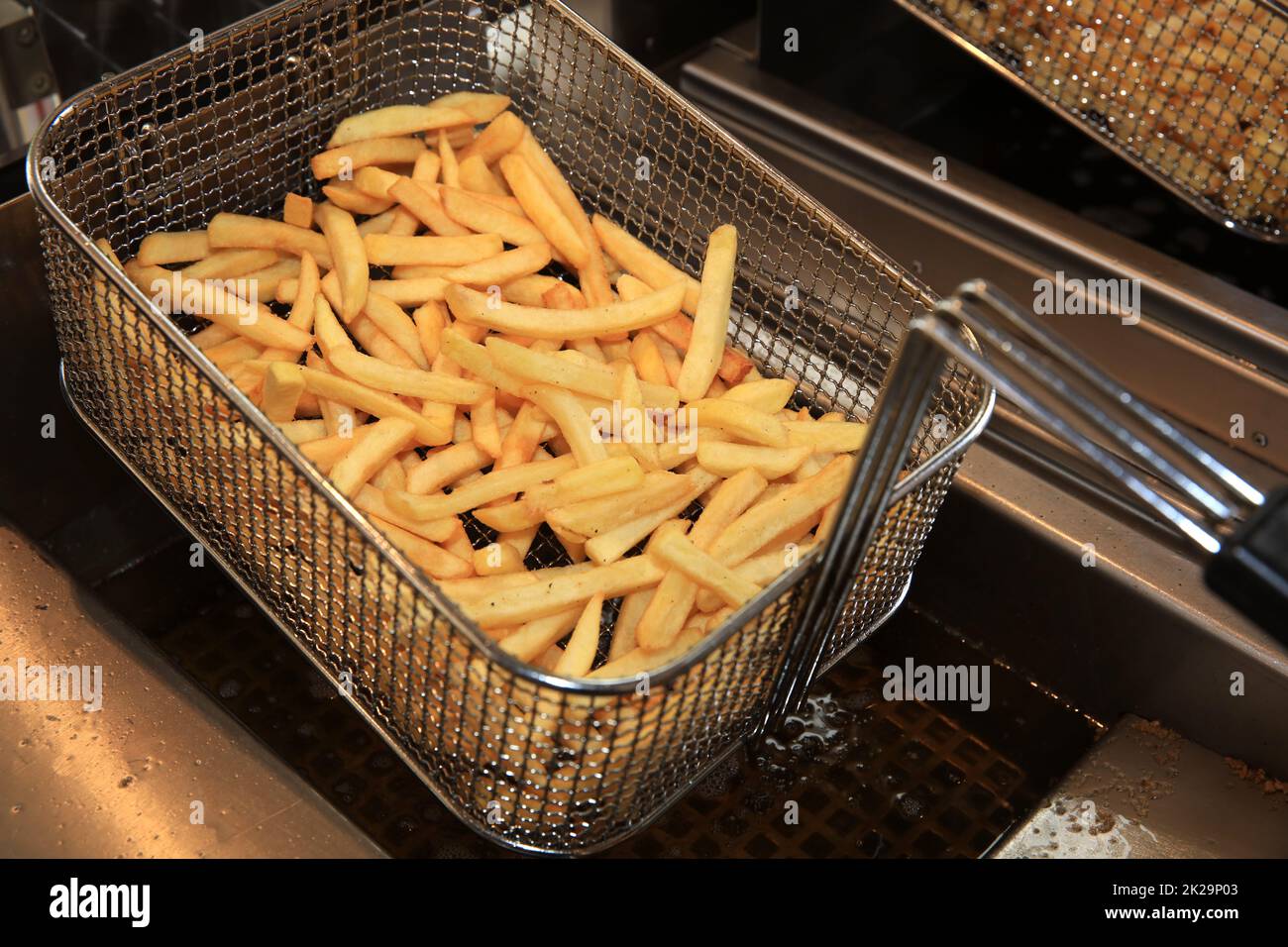 French Fries in Fry Steel Basket on Street Market in Germania Foto Stock
