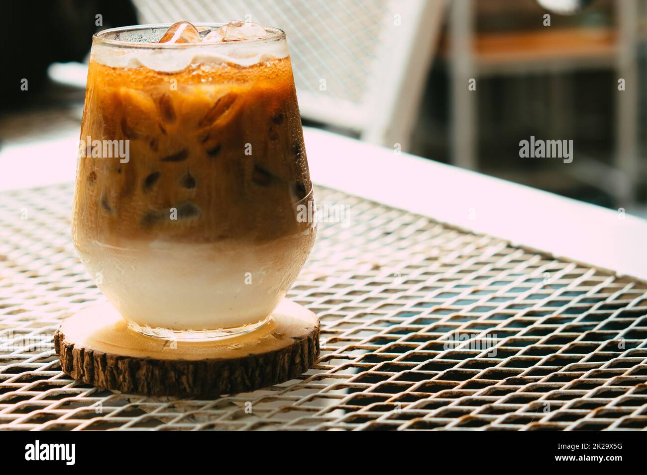 Caffè latte ghiacciato in un bicchiere con panna sul fondo. Freddo fondo di bevanda estiva Foto Stock