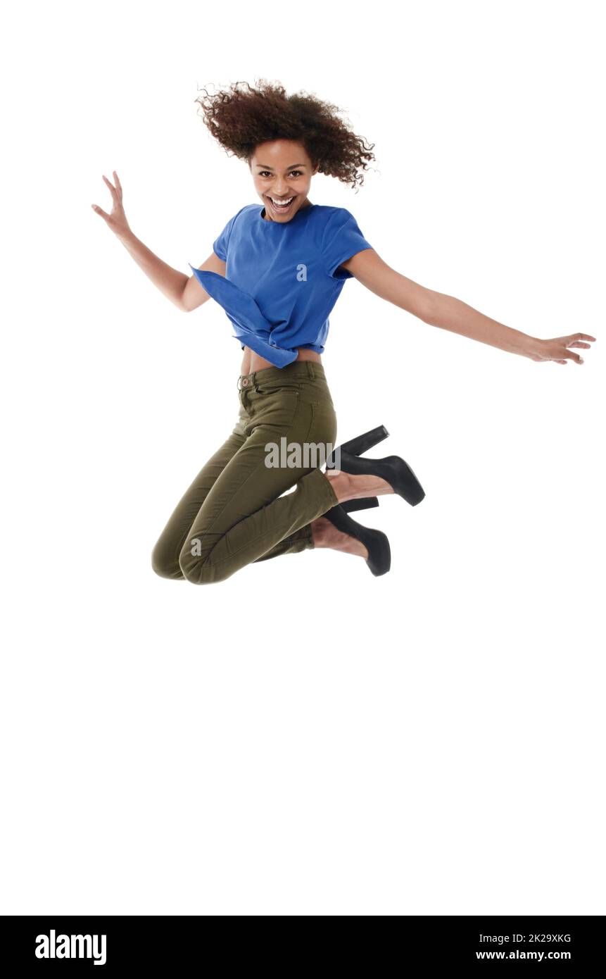 Energia giovanile ed esuberanza. Giovane donna africana che salta con un sorriso mentre isolata su bianco. Foto Stock