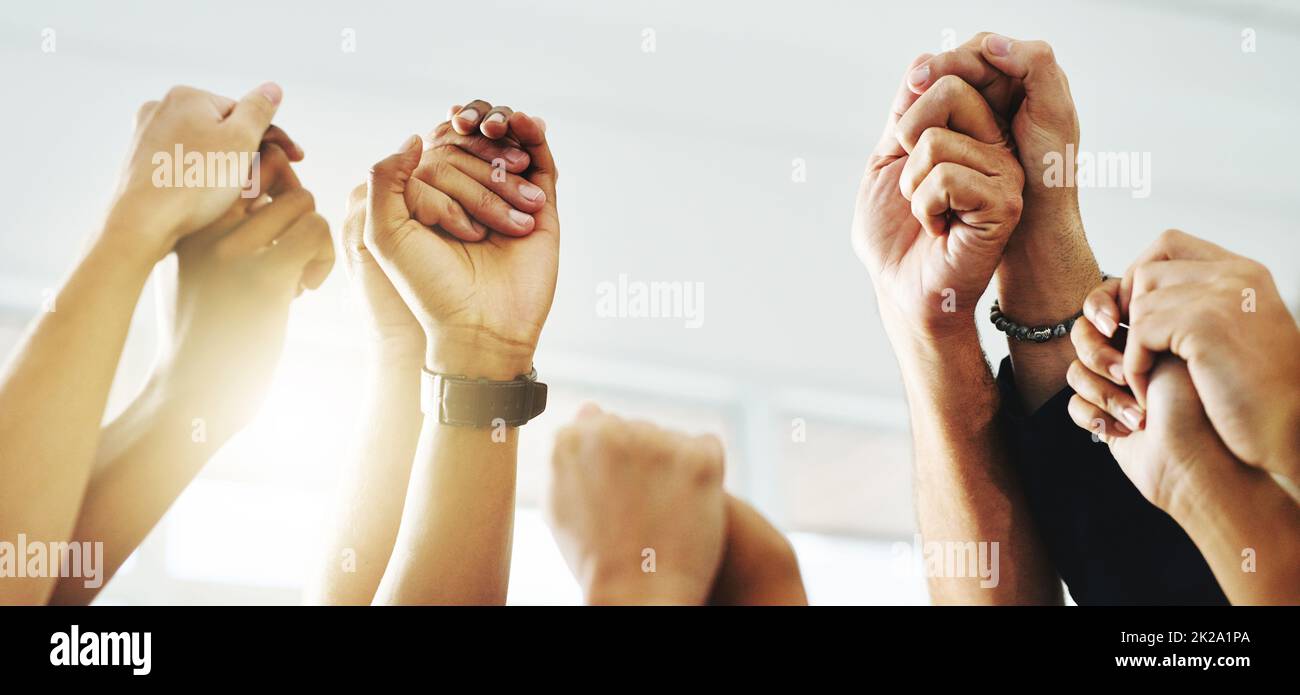 Erano forti e alti. Primo piano di un gruppo di uomini d'affari irriconoscibili che tengono le mani mentre sollevano le braccia. Foto Stock