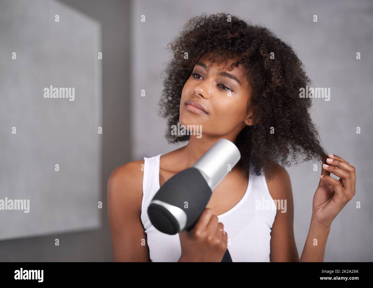 Dando ai capelli il trattamento completo del corso. Scatto di una giovane donna attraente che si prende cura dei suoi capelli. Foto Stock