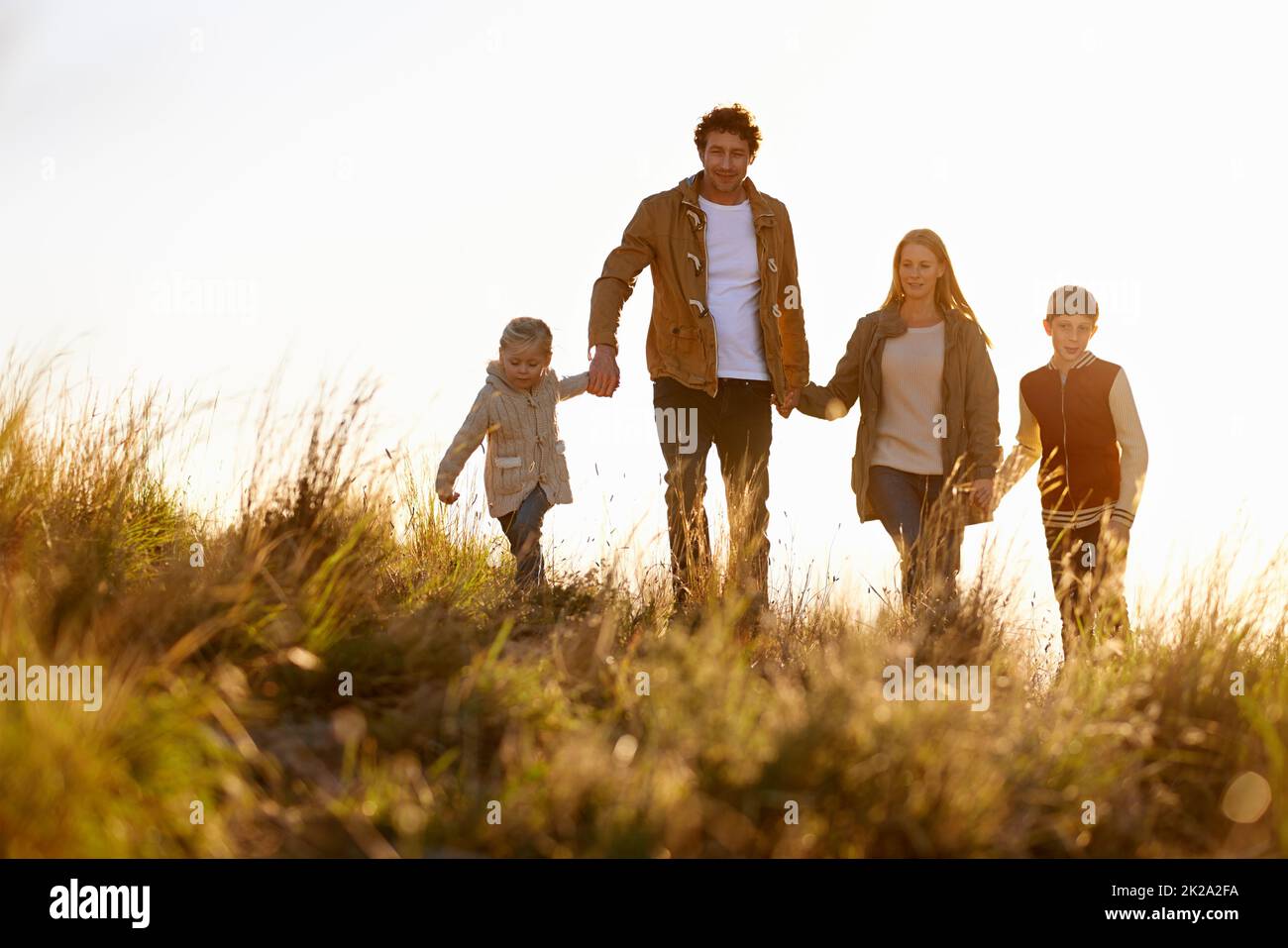 In campi d'oro. Scatto di una famiglia felice fuori in una passeggiata mattutina insieme. Foto Stock