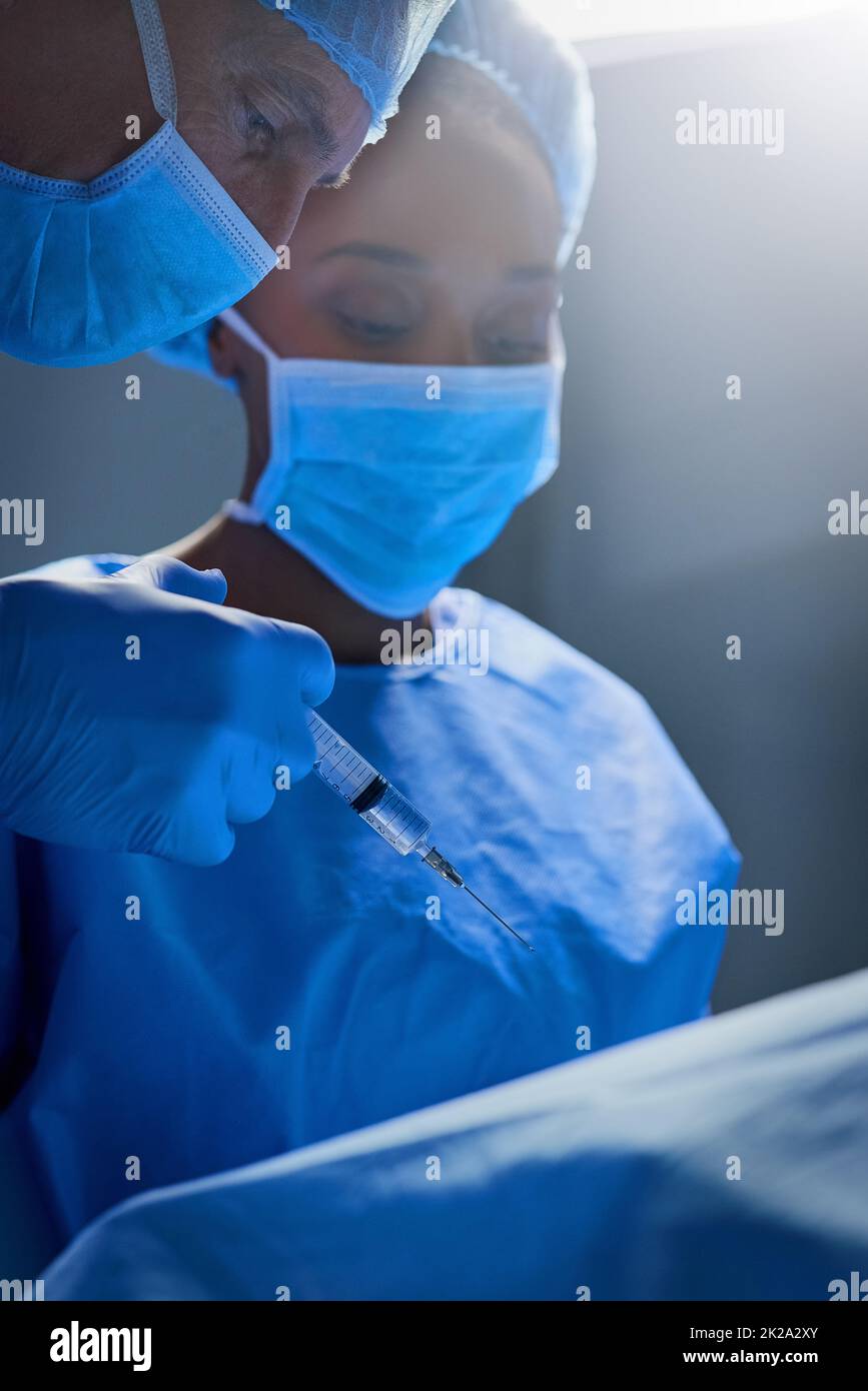 Anestesiizzazione del paziente. Shot di gruppo di chirurghi che lavorano su un paziente in una sala operatoria. Foto Stock