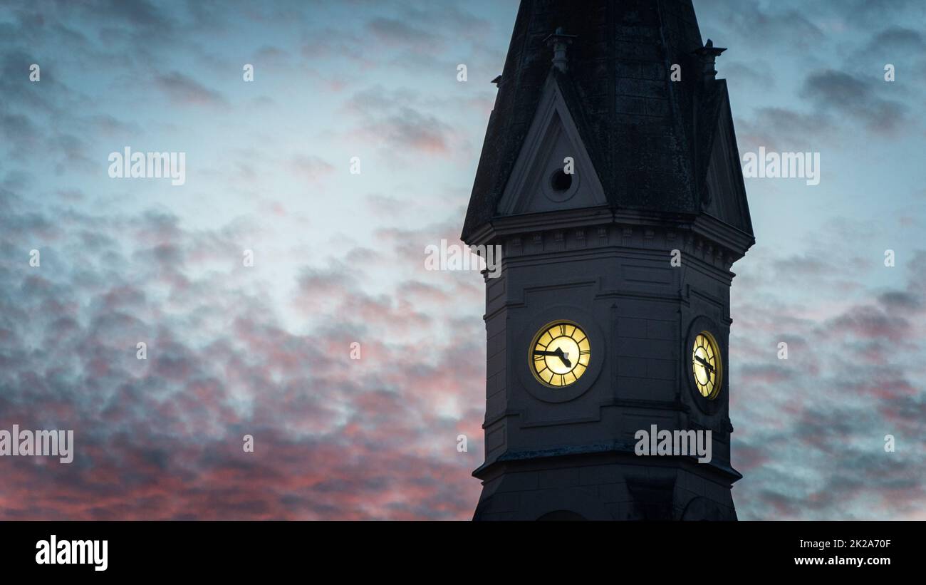 Orologio vecchia chiesa contro il tramonto Foto Stock
