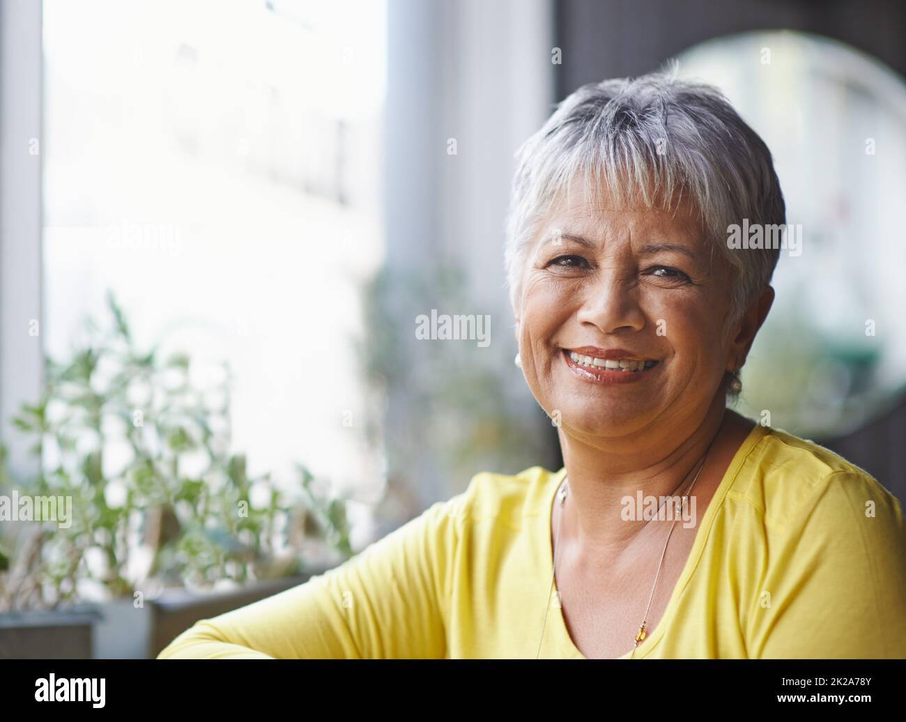 Un'altra giornata di sole in città. Ritratto di una donna matura seduta in una caffetteria. Foto Stock