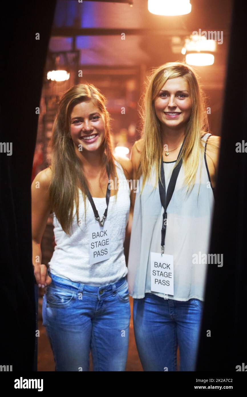 Due giovani donne con pass per il backstage in un concerto. Questo concerto è stato creato per l'unico scopo di questo servizio fotografico, con 300 modelli e 3 band dal vivo. Tutte le persone in questo sparo sono modello rilasciato. Foto Stock