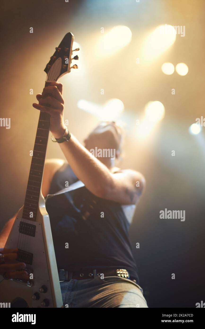 Un chitarrista suona il suo cuore sotto le luci strobe. Questo concerto è stato creato per l'unico scopo di questo servizio fotografico, con 300 modelli e 3 band dal vivo. Tutte le persone in questo sparo sono modello rilasciato. Foto Stock