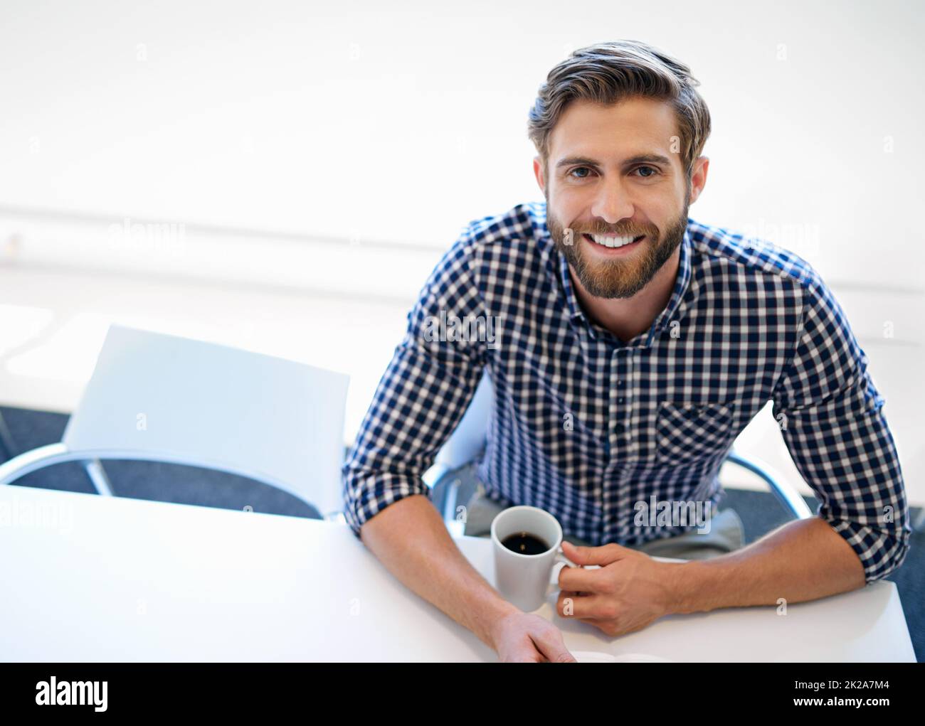 Pronto per affrontare la giornata lavorativa. Ritratto di un bel uomo d'affari seduto con una tazza di caffè alla sua scrivania. Foto Stock