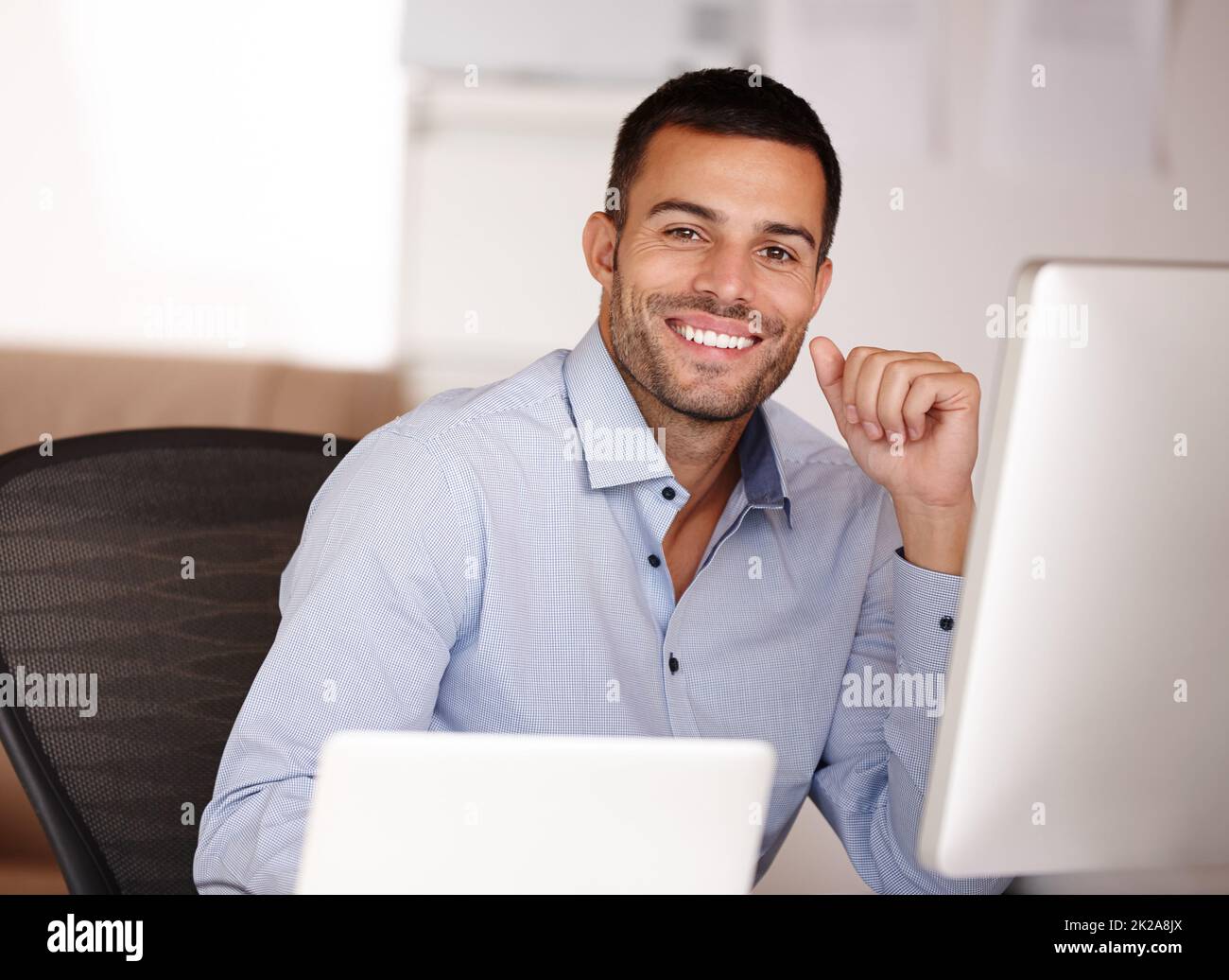 Se vuoi il meglio allora scegli me. Ritratto di un giovane sorridente seduto dietro uno schermo del computer. Foto Stock