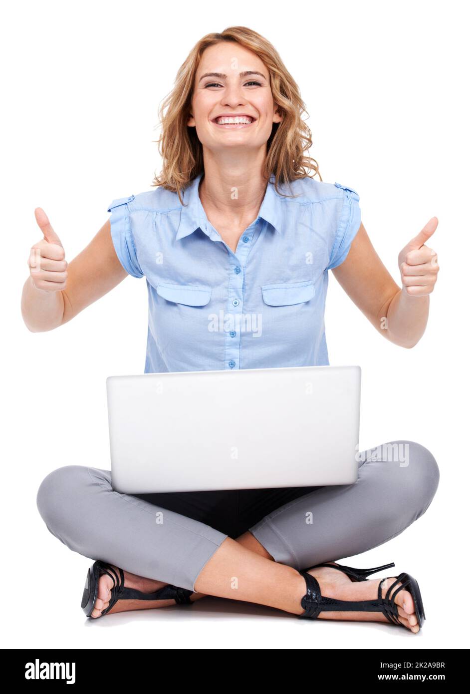 Darti il thumbsup. Ritratto a tutta lunghezza di una giovane donna attraente che dà due pollici in su mentre usando il suo laptop. Foto Stock