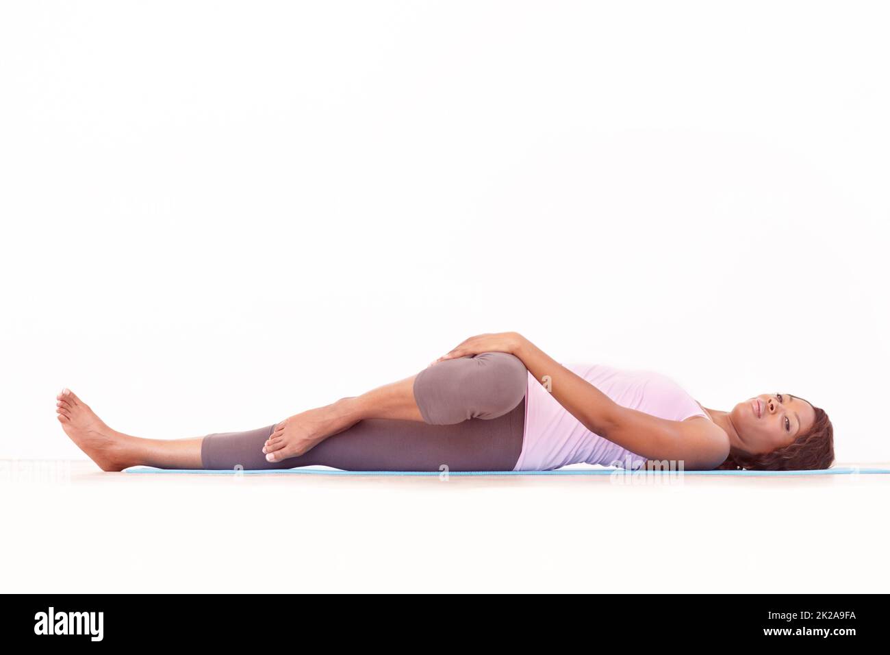 Lavorare tutti i muscoli e le articolazioni. Una giovane donna afroamericana che esegue una routine di yoga. Foto Stock