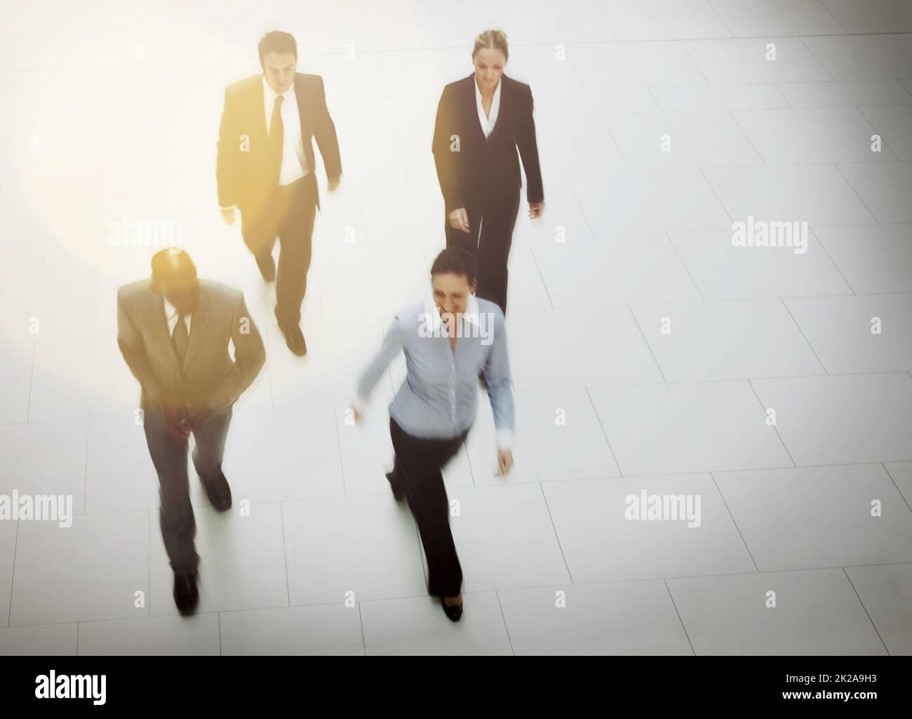 Dirigersi verso l'ufficio. Inquadratura ad alto angolo di un gruppo di uomini d'affari che camminano attraverso la lobby dell'ufficio. Foto Stock
