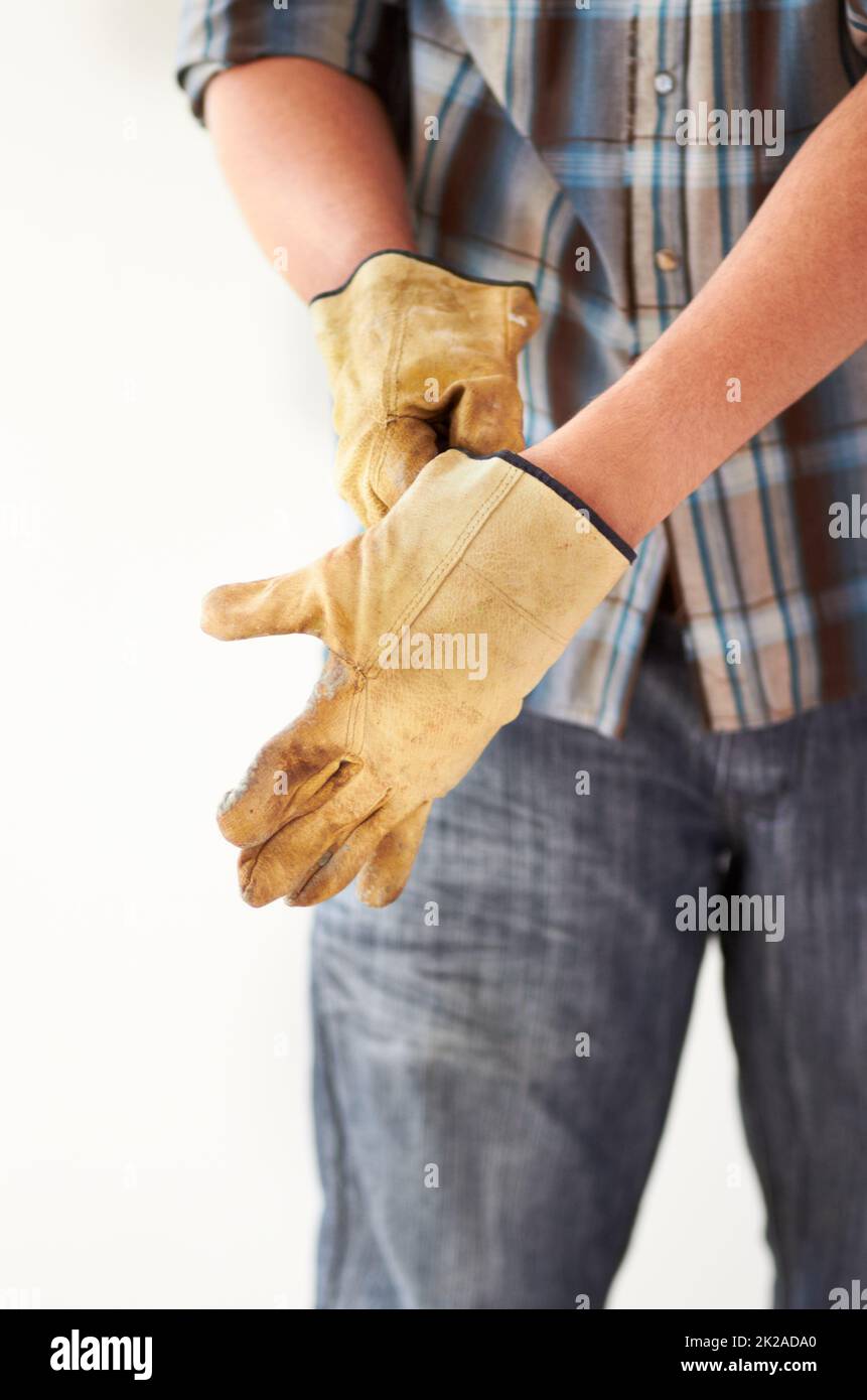 Preparatevi per il lavoro a mano. Immagine ritagliata di un uomo che indossa i guanti. Foto Stock