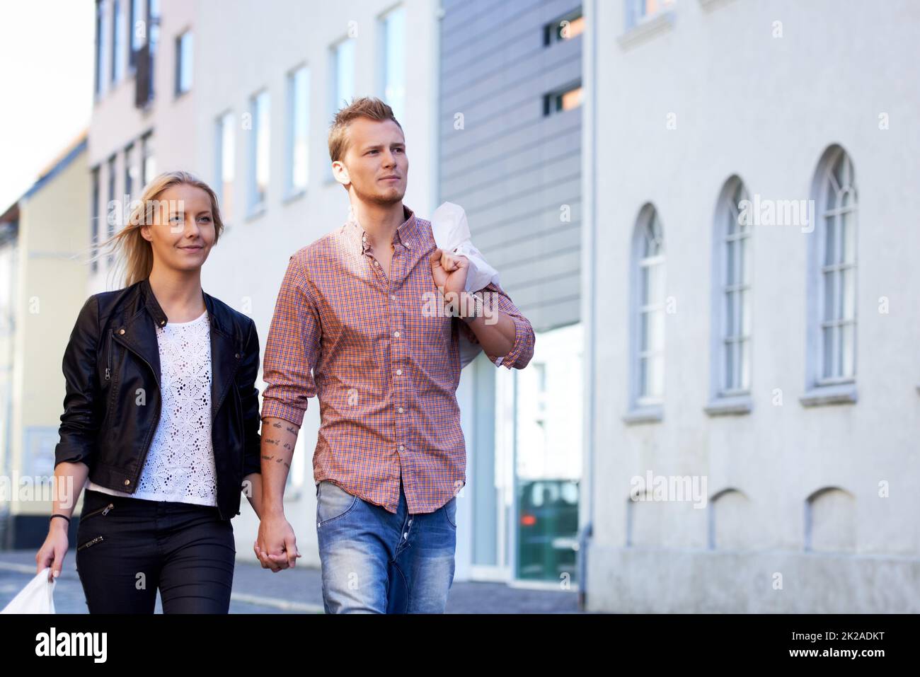 Passeggiando per le strade. Una giovane coppia felice che cammina a mano per le strade. Foto Stock