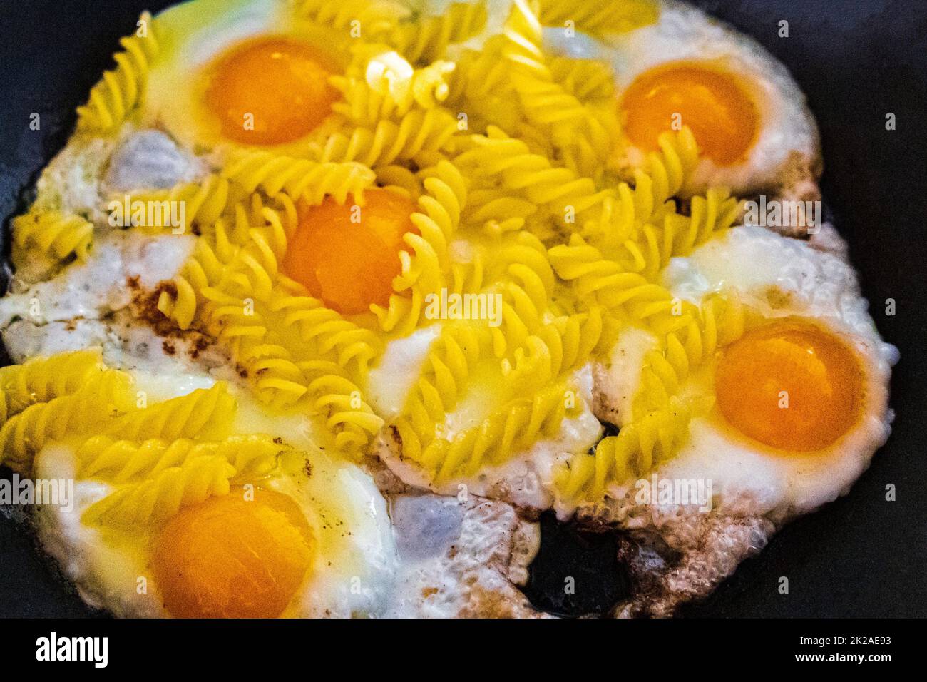 Friggere le uova e preparare tagliatelle di uova fritte nella padella. Foto Stock