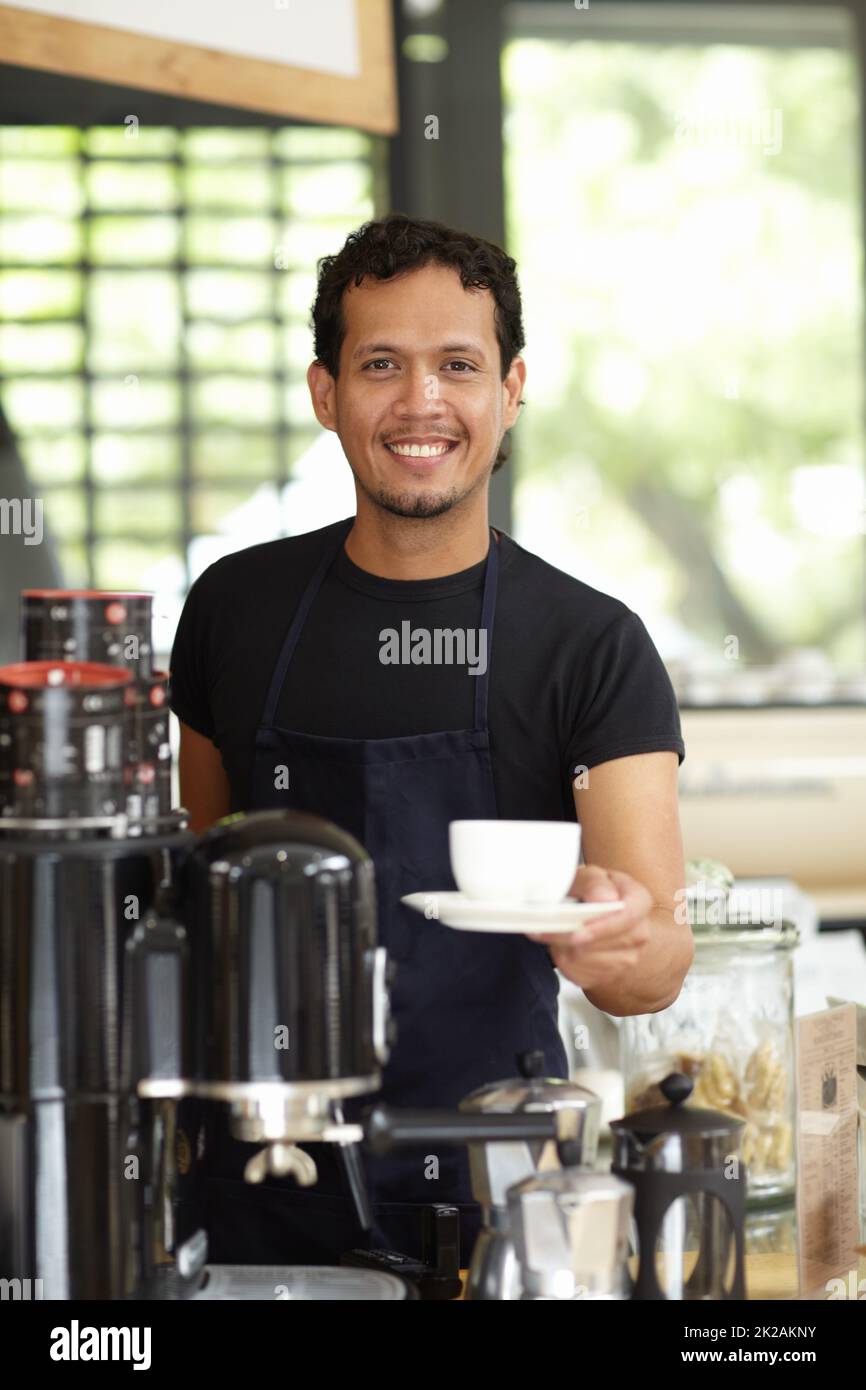 Fantasia una tazza fresca di joe. Shot di un bel barista che serve una tazza di caffè fresco. Foto Stock