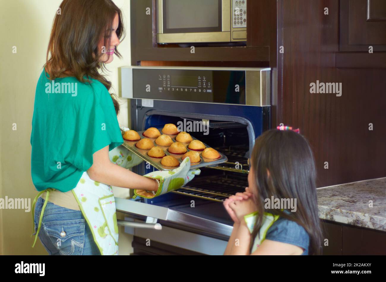 Questi look sono perfetti. Carino ragazza che cuoce con la sua nanny a casa. Foto Stock