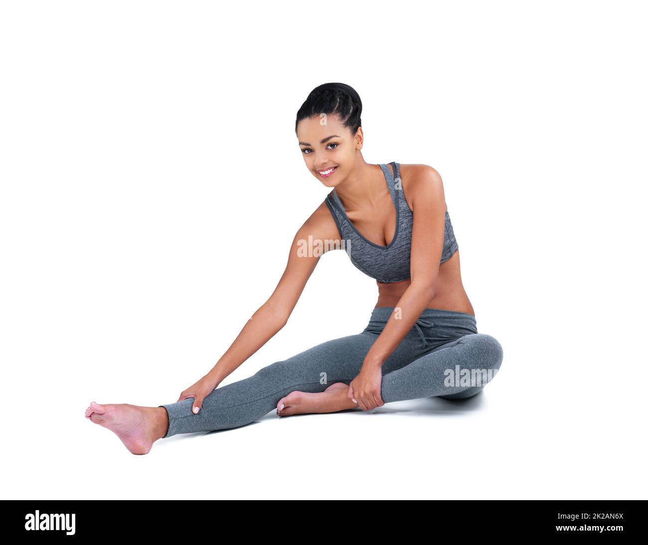 Mi stretch prima di ogni allenamento. Ritratto a tutta lunghezza di un atleta femminile che si estende su uno sfondo bianco. Foto Stock