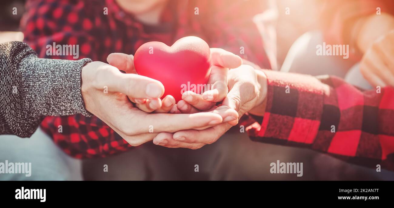 Madre, padre e figlio che tengono in mano un simbolo di cuore Foto Stock