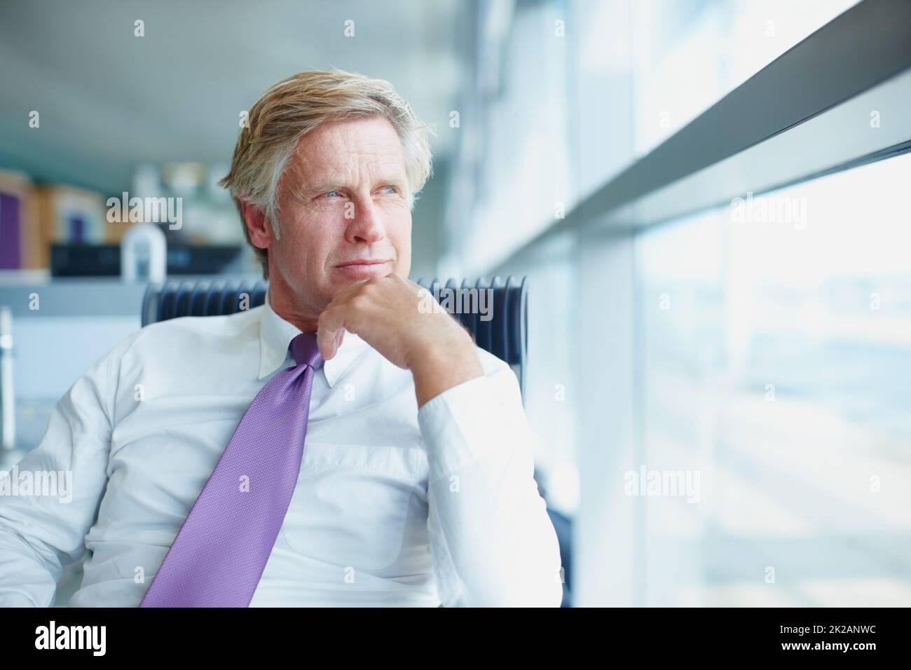 Guardando al futuro. Ritratto di bel uomo d'affari che guarda attraverso la finestra. Foto Stock