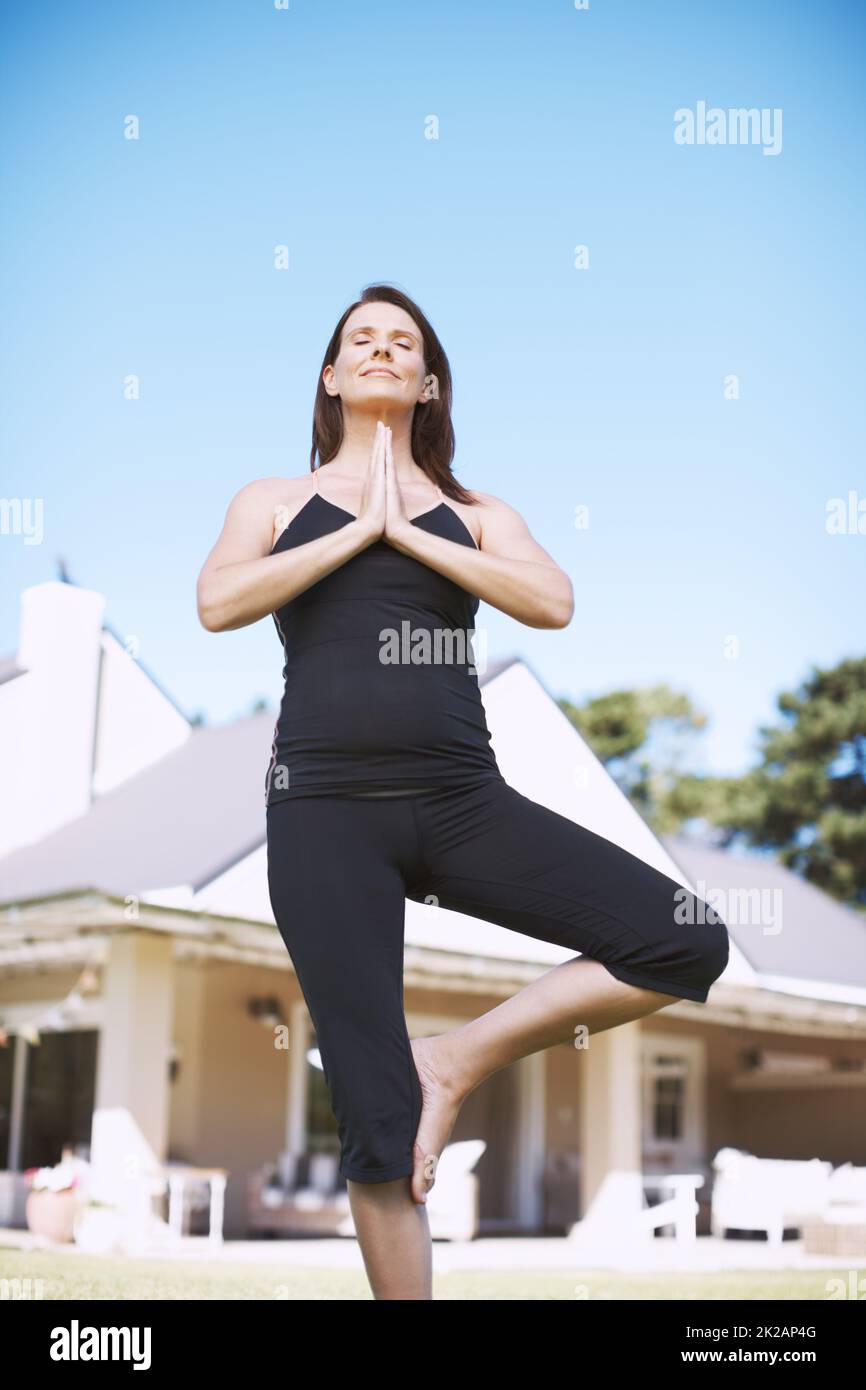 Focalizzato sulla ricerca della pace. Una donna attraente che pratica lo yoga fuori con le sue mani in positon di preghiera. Foto Stock