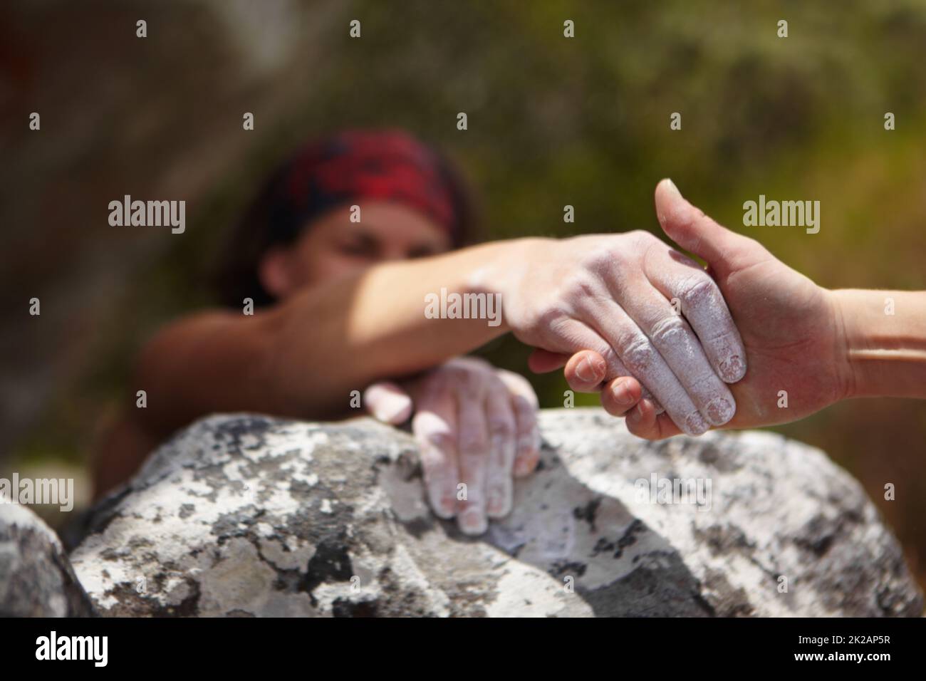 Una mano d'aiuto. Un arrampicatore di roccia che dà una mano d'aiuto ad un altro. Foto Stock