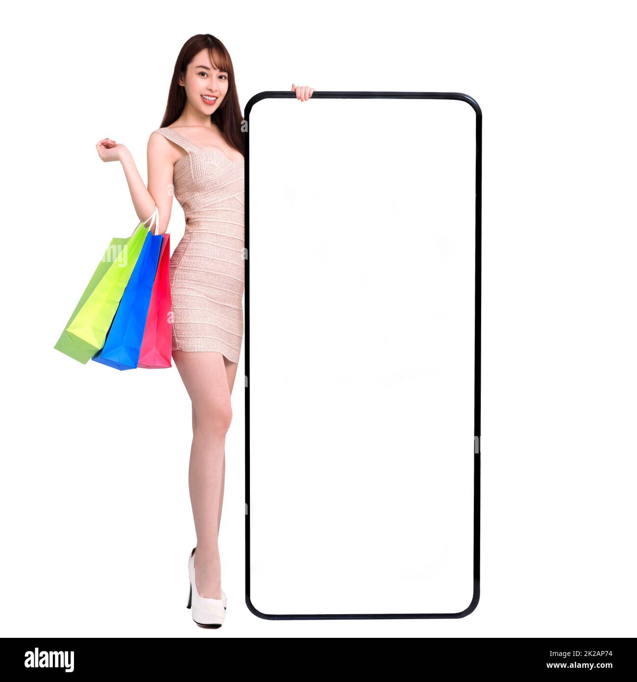 Felice giovane donna in piedi e pendente grande smartphone con schermo bianco vuoto. Shopping online con i concetti di telefono cellulare Foto Stock