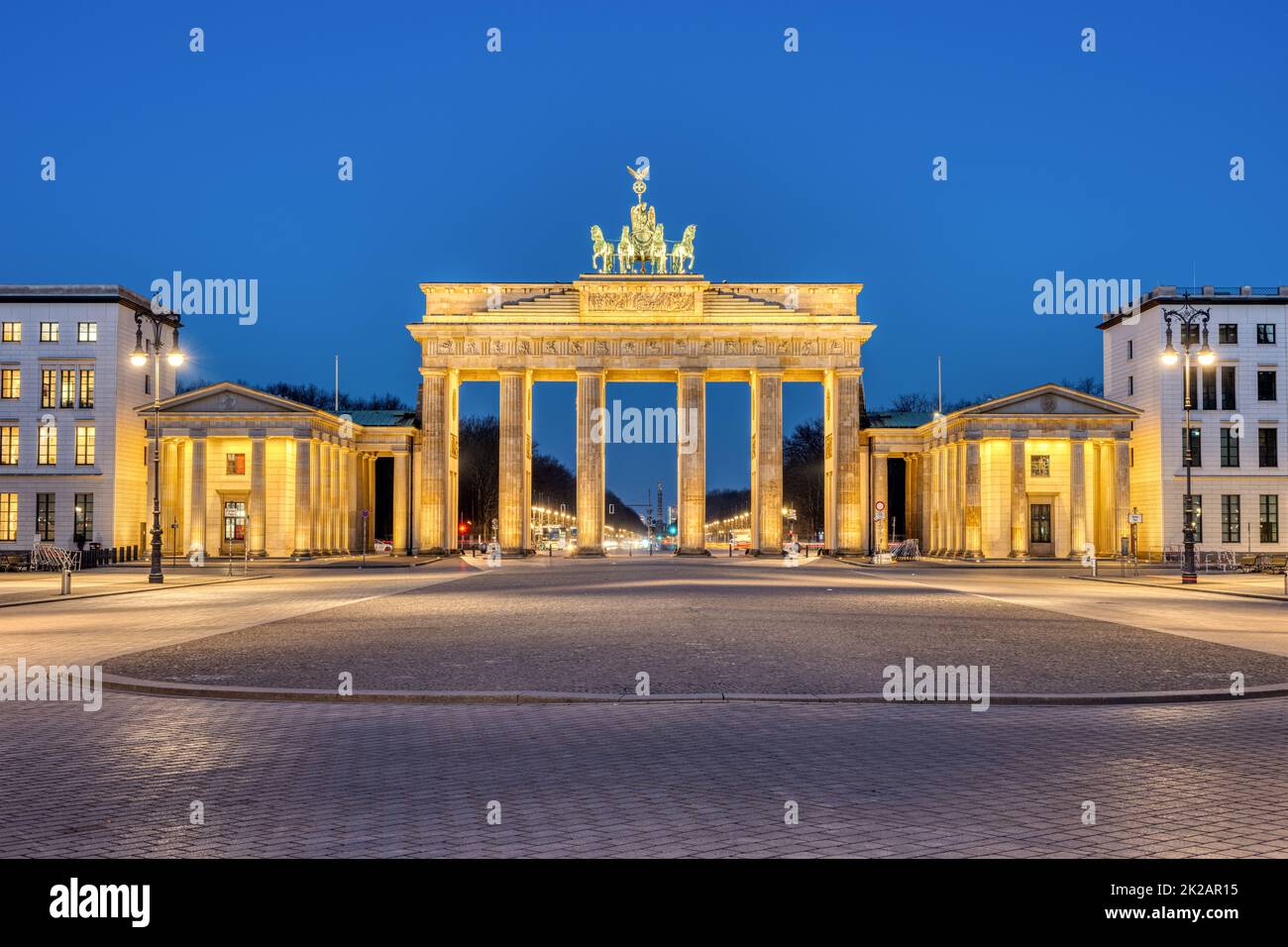 La porta di Brandeburgo illuminata a Berlino all'alba Foto Stock