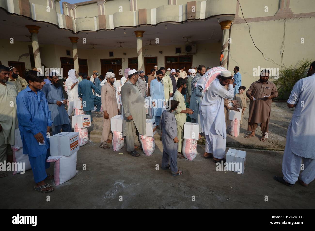 Peshawar, Khyber Pakhtunkhwa, Pakistan. 22nd Set, 2022. Le persone colpite dalle inondazioni ricevono aiuti di soccorso distribuiti dalla Fondazione al Khidmat nel distretto di Nowshera, villaggio di Garhi Momin, provincia di Khyber Pakhtunkhwa. (Credit Image: © Hussain Ali/Pacific Press via ZUMA Press Wire) Foto Stock